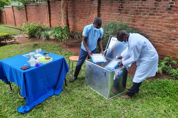 Zwei Männer verpacken Equipment eines Augecamps in eine ZARGES Eurobox