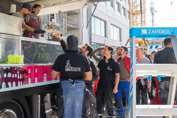 Im Vordergrund die Multimaster 5 zusehen. Ein Foodtruck mit anstehenden Menschen im Hintergrund