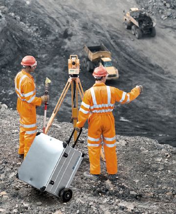 Zwei Personen in Orangenen Overalls führen Messungen durch, die Messmittel sind in einer Mobil Box verstaut.