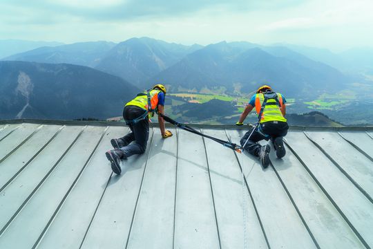 Zwei Industriekletterer nehmen eine Dachwartung vor, dabei sind sie von der ZARGES FallProtection Ausrüstung gesichert