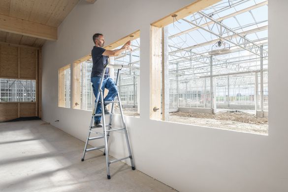 Handwerker bei Arbeit auf einer einseitig begehbaren ZARGES Stehleiter