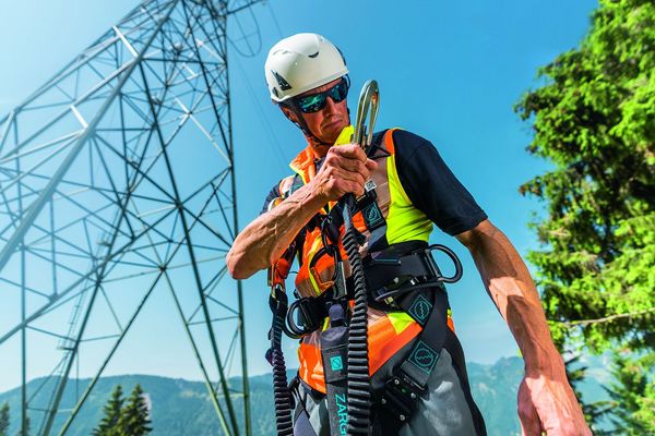 Industriekletterer während der Vorbereitung auf seine Arbeitsplatzpositionierung mit vollständiger Fall Protection-Ausrüstung